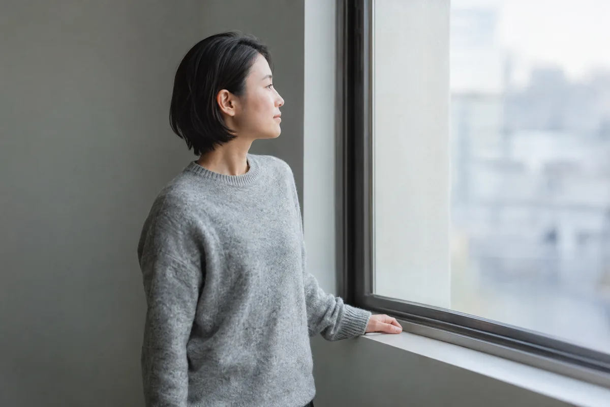 窓辺で考えごとをする人
